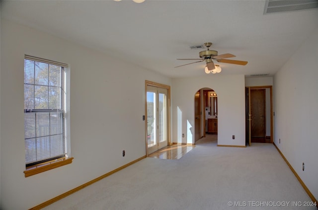 17808 S 129th E Ave, Bixby, OK 74008 - spare room with arched walkways, ceiling fan, light carpet, and baseboards