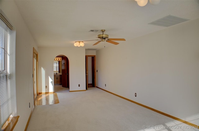 17808 S 129th E Ave, Bixby, OK 74008 - empty room featuring arched walkways, light colored carpet, a ceiling fan, and baseboards