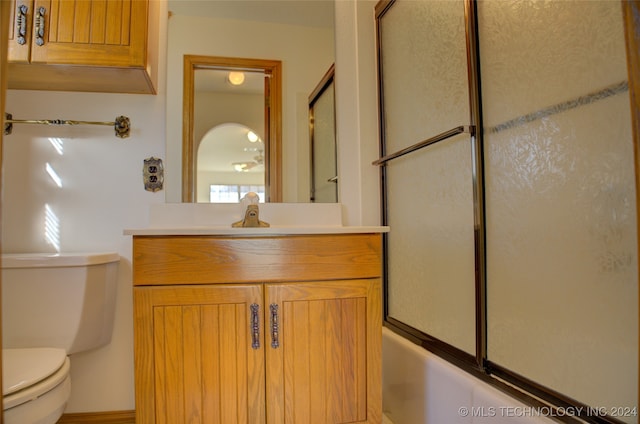 full bathroom with vanity, toilet, and enclosed tub / shower combo