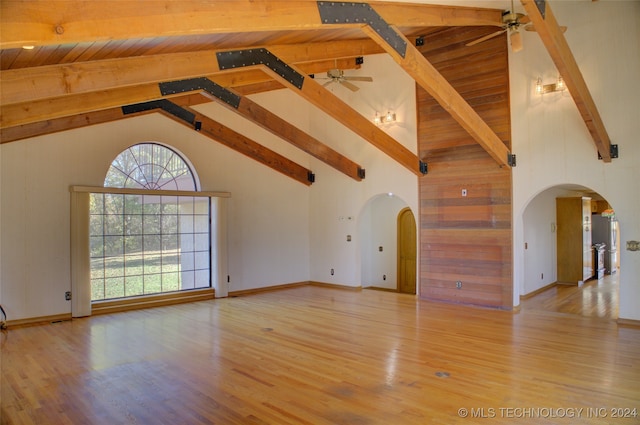 unfurnished living room featuring beamed ceiling, wood-type flooring, and high vaulted ceiling