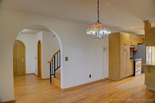 17808 S 129th E Ave, Bixby, OK 74008 - kitchen with stainless steel range with gas cooktop, light wood finished floors, arched walkways, hanging light fixtures, and a chandelier