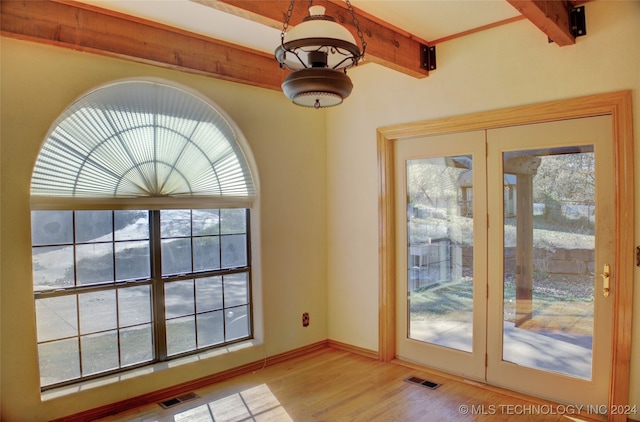 doorway with beamed ceiling, a healthy amount of sunlight, french doors, and light hardwood / wood-style flooring