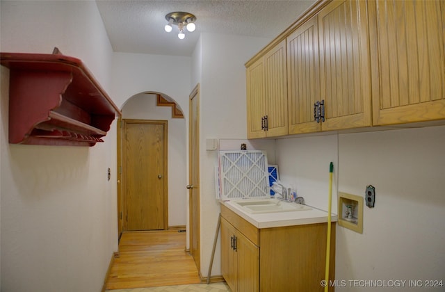 17808 S 129th E Ave, Bixby, OK 74008 - washroom with washer hookup, cabinet space, arched walkways, light wood-style floors, and a textured ceiling