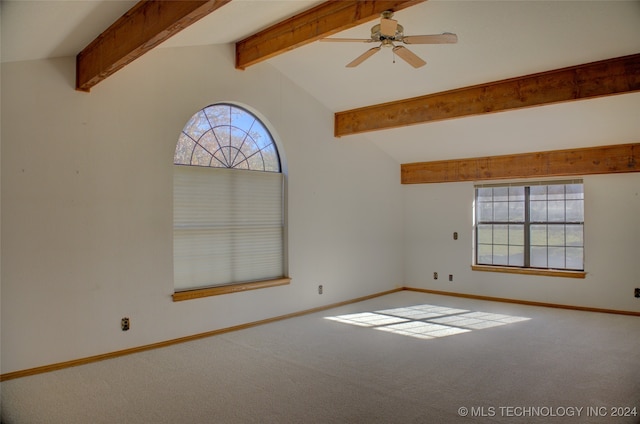 carpeted spare room with lofted ceiling with beams, ceiling fan, and a healthy amount of sunlight