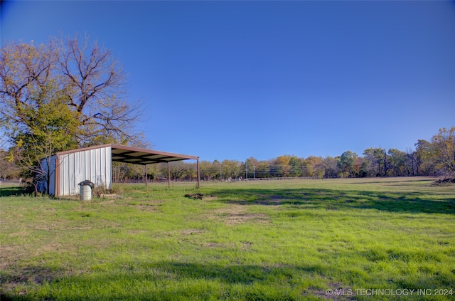 view of yard with a rural view and an outdoor structure