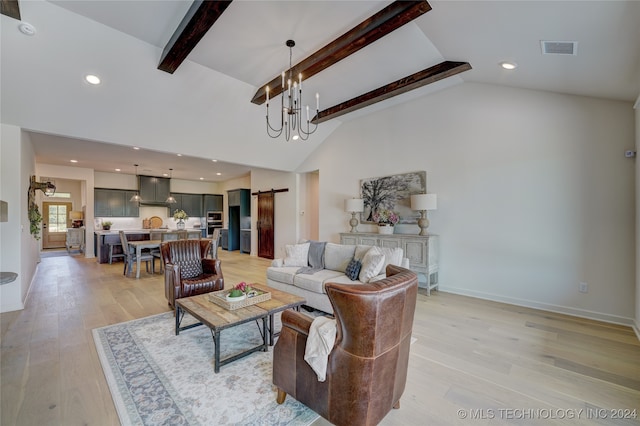 living room featuring vaulted ceiling with beams, a barn door, light hardwood / wood-style floors, and an inviting chandelier