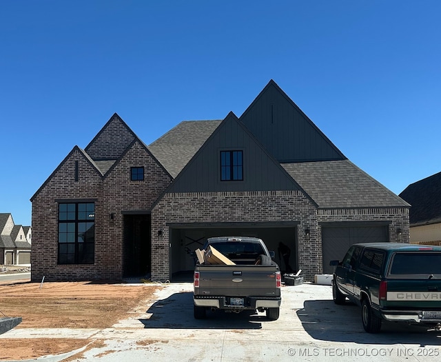 view of front of house featuring concrete driveway, brick siding, and a shingled roof