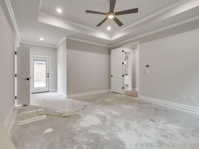 empty room with ceiling fan, a tray ceiling, and ornamental molding