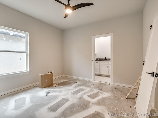 interior space with ceiling fan, sink, and ensuite bath