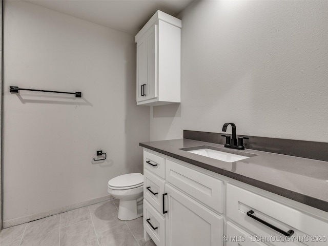 bathroom with toilet, vanity, and tile patterned flooring