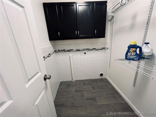 laundry room featuring cabinets, tile walls, and dark wood-type flooring