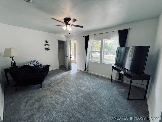 sitting room with ceiling fan and dark carpet