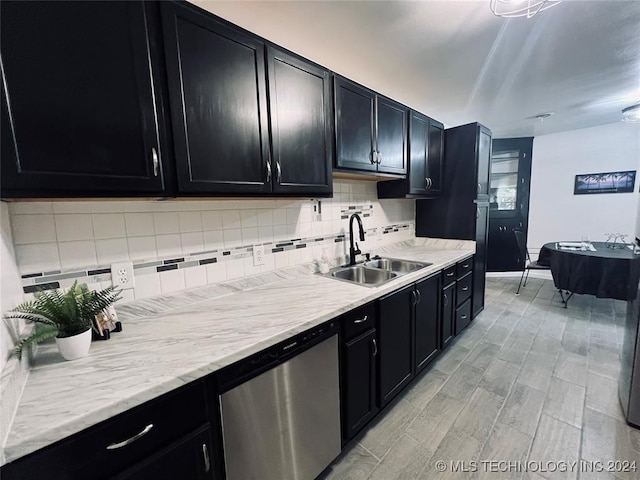 kitchen with stainless steel dishwasher, tasteful backsplash, sink, and light hardwood / wood-style flooring