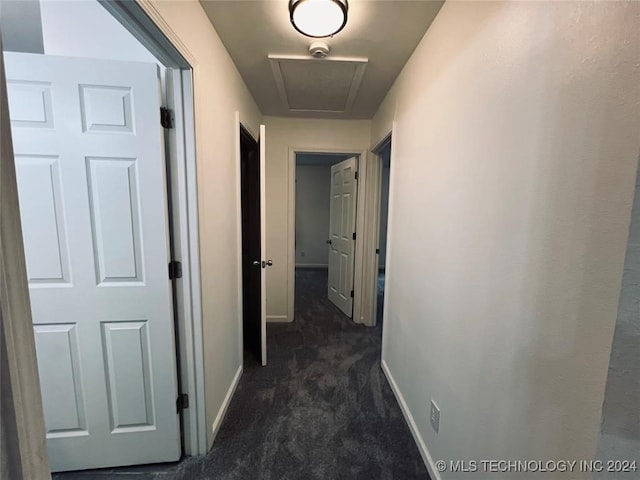 hallway with dark colored carpet