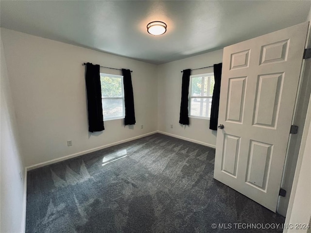 empty room featuring dark carpet