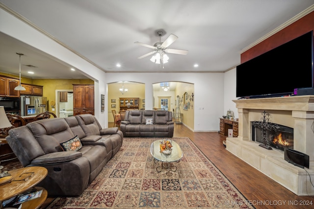 living room with a fireplace, hardwood / wood-style flooring, ceiling fan, and crown molding