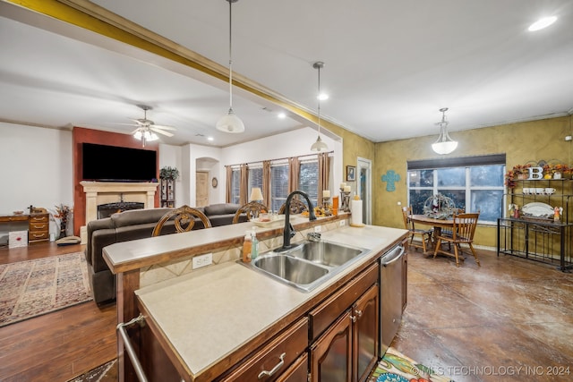 kitchen with dishwasher, a center island with sink, sink, hanging light fixtures, and ceiling fan