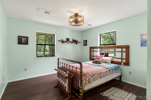 bedroom featuring dark hardwood / wood-style floors and multiple windows