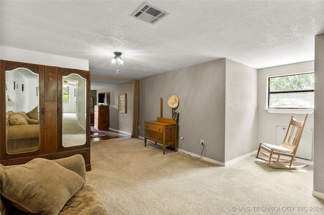 sitting room featuring carpet floors and a textured ceiling