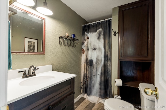 bathroom featuring vanity, hardwood / wood-style floors, a shower with curtain, and toilet