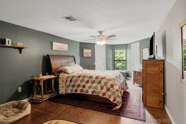 bedroom featuring ceiling fan, hardwood / wood-style floors, and a textured ceiling