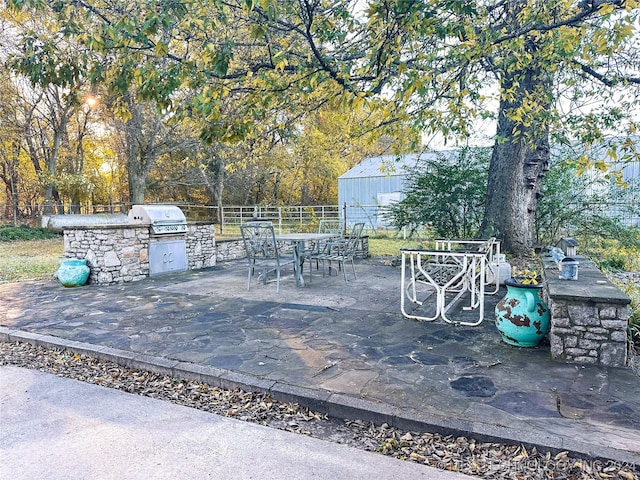 view of patio featuring exterior kitchen and a grill