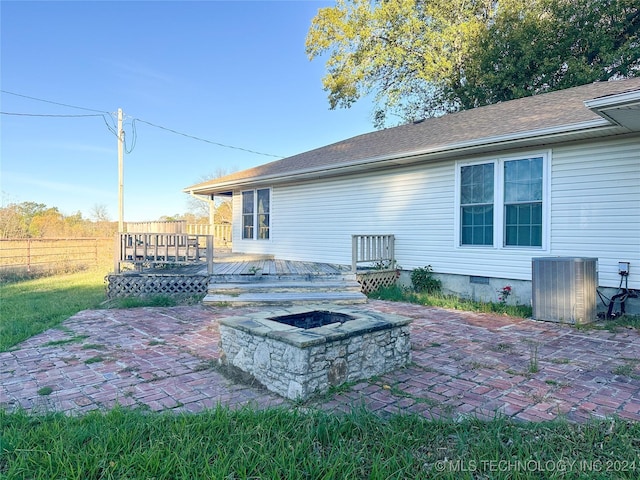 back of house featuring a wooden deck, a patio area, a fire pit, and central AC