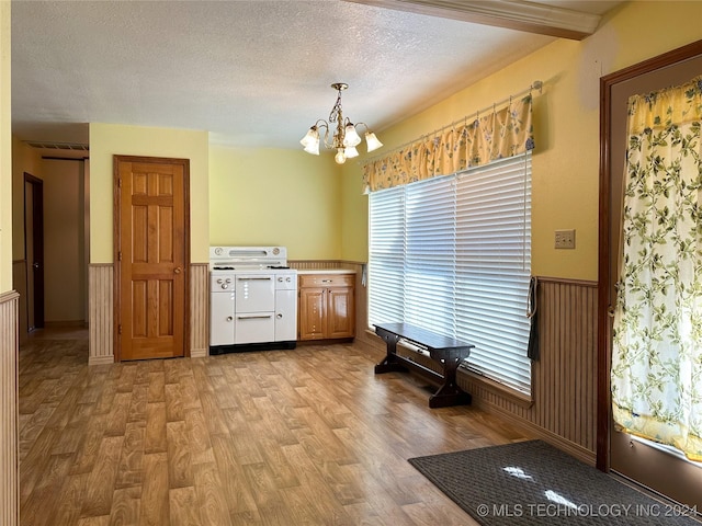 dining room featuring a notable chandelier, a textured ceiling, and light hardwood / wood-style flooring