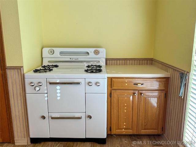 kitchen with white range with gas cooktop and dark hardwood / wood-style floors