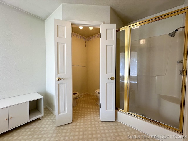 bathroom featuring toilet and an enclosed shower