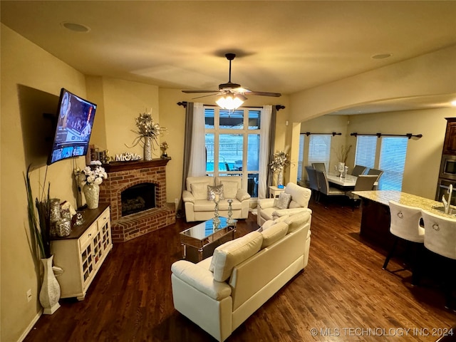 living room featuring a fireplace, ceiling fan, and dark hardwood / wood-style flooring