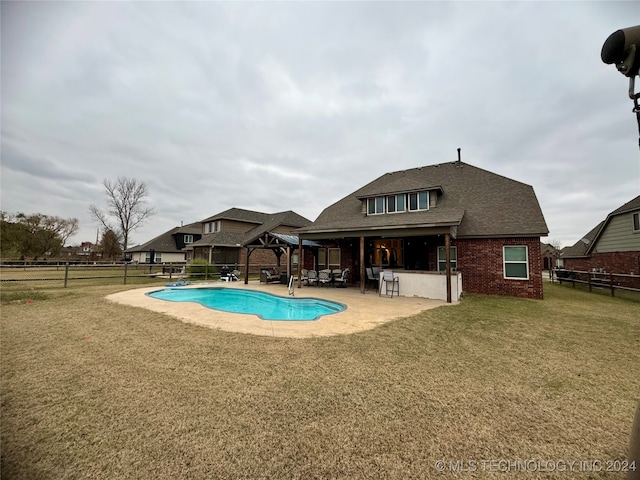 view of swimming pool featuring a yard, an outdoor bar, and a patio area