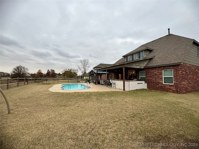 view of pool with a lawn and a patio