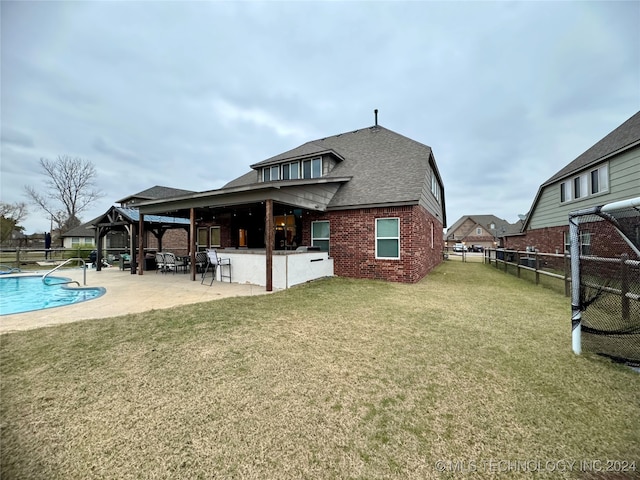 back of house featuring a fenced in pool, a patio area, and a yard