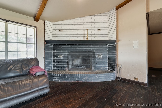 living room with hardwood / wood-style flooring, vaulted ceiling with beams, and a brick fireplace