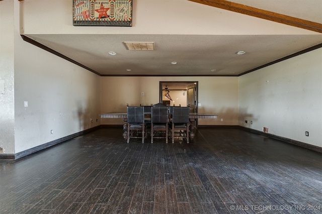 dining space featuring crown molding, dark wood-type flooring, and a textured ceiling