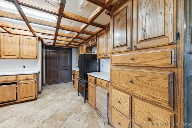 kitchen with black fridge, beamed ceiling, and coffered ceiling