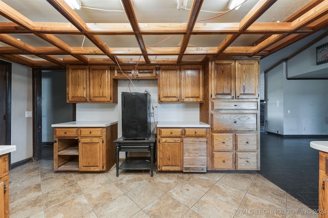 kitchen featuring light tile patterned floors and coffered ceiling