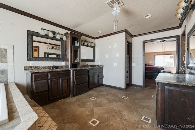 bathroom featuring vanity, ceiling fan, crown molding, and a textured ceiling