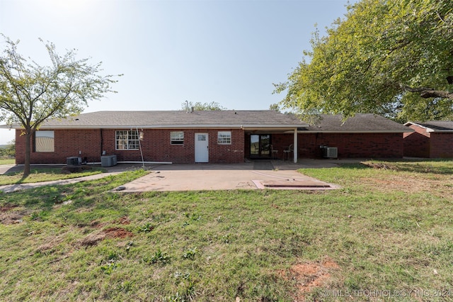 rear view of house with a lawn, cooling unit, and a patio