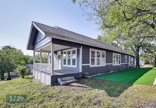 view of property exterior with a porch and a yard