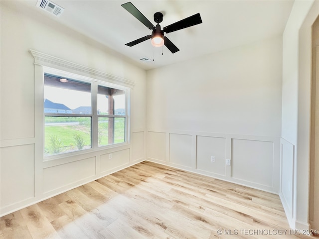 spare room featuring ceiling fan, a mountain view, and light wood-type flooring