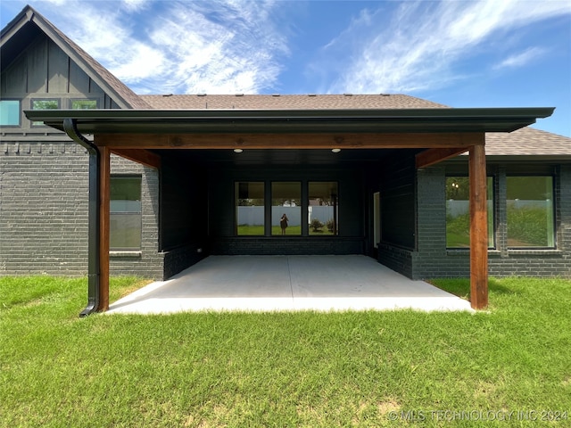 rear view of property with a yard and a patio area