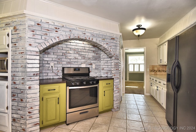 kitchen featuring green cabinets, light tile patterned flooring, appliances with stainless steel finishes, and tasteful backsplash