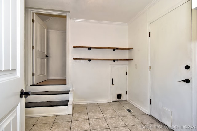 laundry room featuring ornamental molding and light tile patterned floors