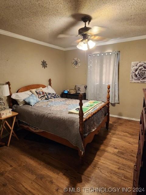 bedroom featuring ceiling fan, hardwood / wood-style floors, and a textured ceiling