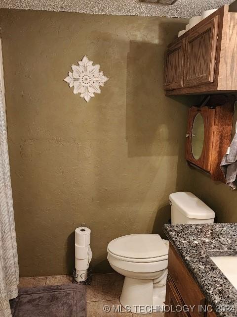 bathroom featuring tile patterned flooring, vanity, and toilet