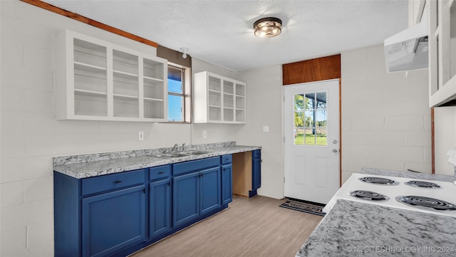 kitchen featuring blue cabinetry, white cabinetry, sink, light hardwood / wood-style flooring, and a textured ceiling