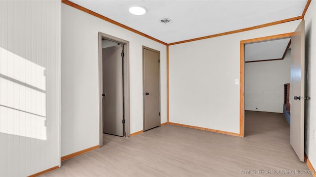 unfurnished bedroom with light hardwood / wood-style flooring, a closet, and crown molding