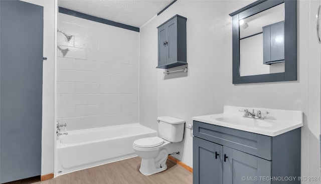 full bathroom featuring hardwood / wood-style floors, vanity, tiled shower / bath combo, toilet, and a textured ceiling